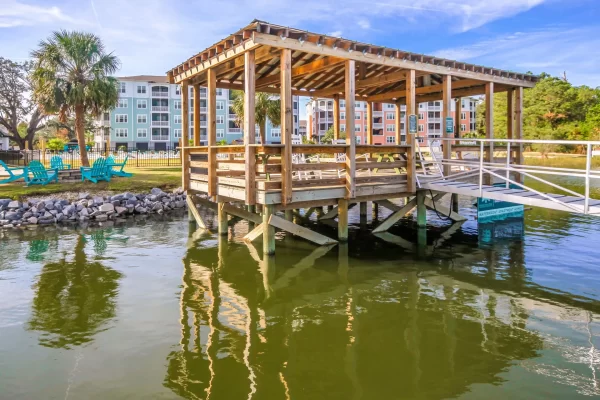 View of the roofed dock from the water with the Sweetwater Apartments property in the background