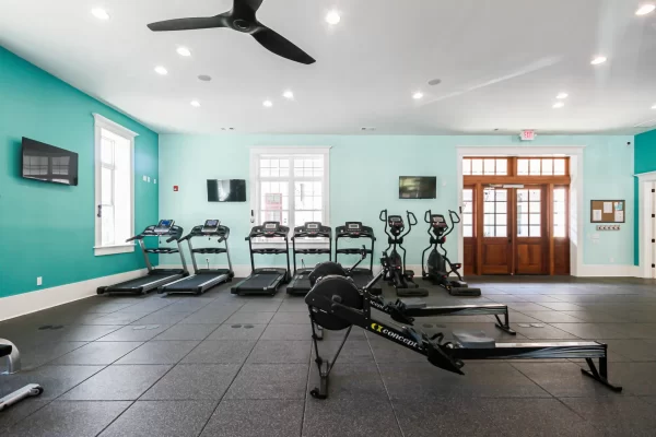 Spacious fitness center featuring cardio equipment, including rowing machines, treadmills, and ellipticals