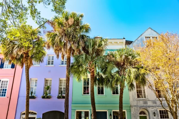 Rainbow Row in historic downtown Charleston, SC with colorful, pastel buildings and palm trees